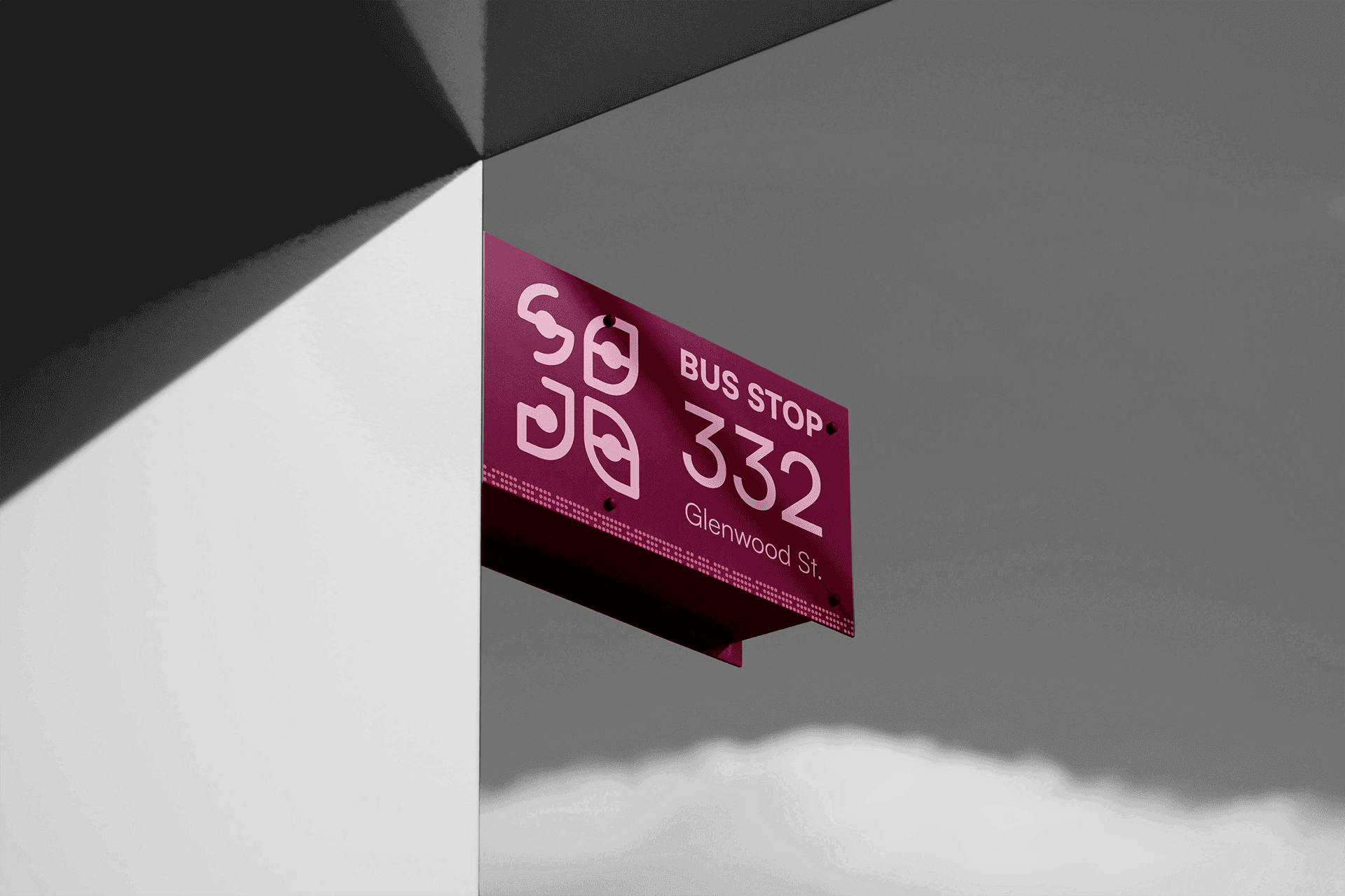a magenta Bus Stop 332, Glenwood St. sign mounted at a building corner beneath the SOJO mark, set against a black-and-white architectural photo