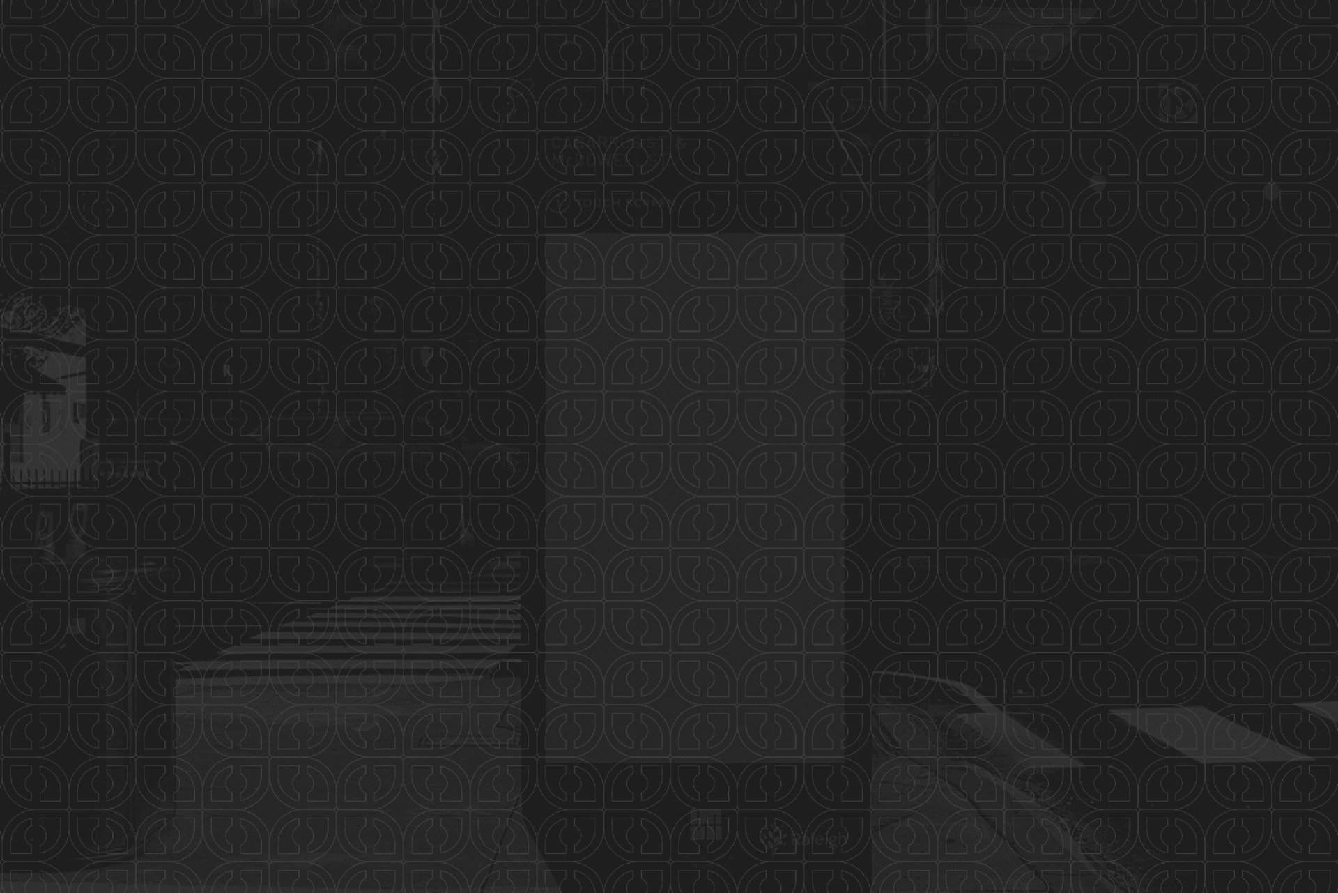 a near-black night photo of a bus shelter kiosk overlaid with the faint O-mark pattern, a bench and a Raleigh wordmark barely visible in the shadows